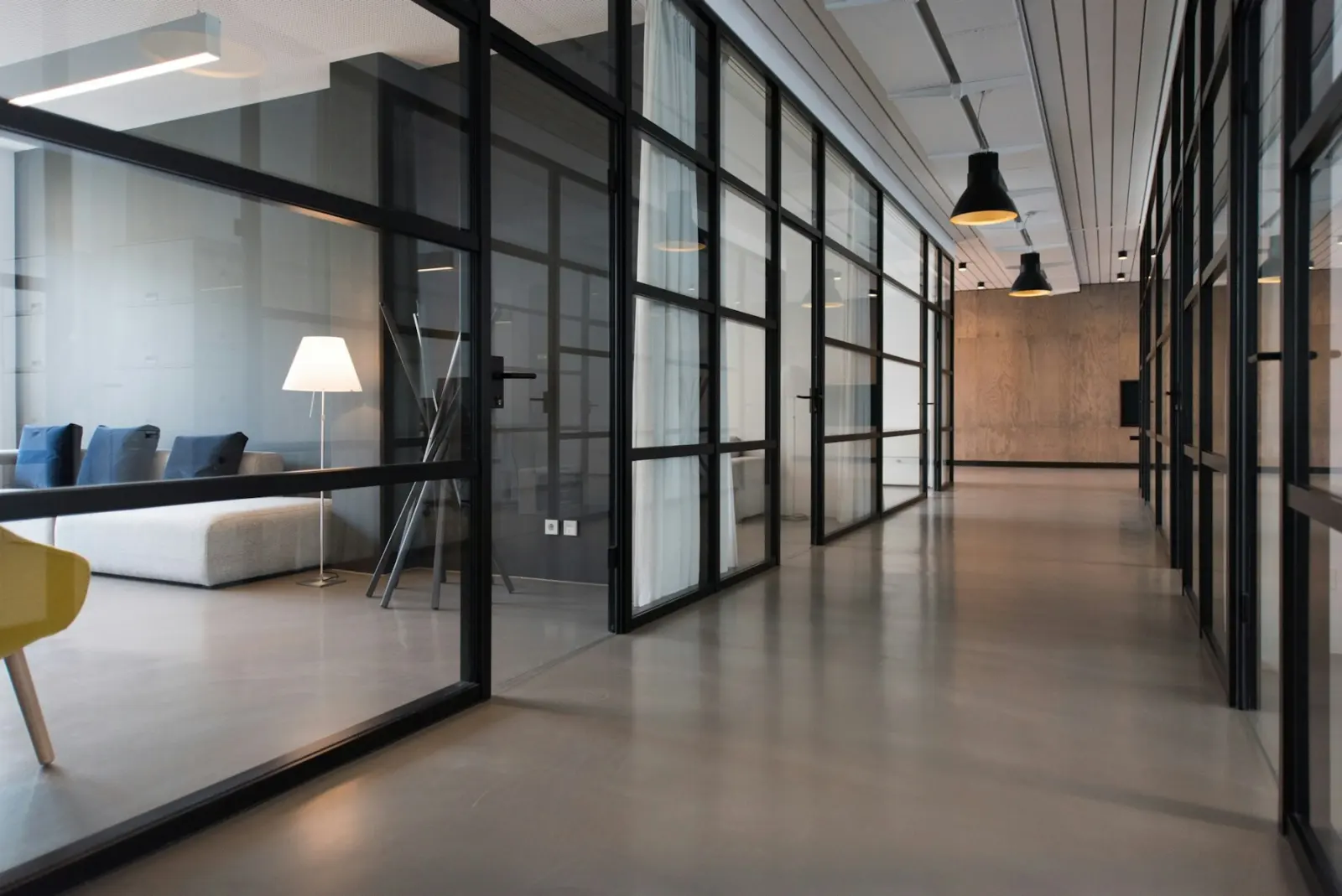 Office corridor lined with black-framed glass partitions, with no graphics applied to any wall — commercial interiors across the mapped area